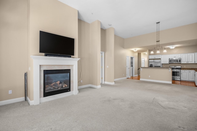 unfurnished living room featuring baseboards, light colored carpet, and a tiled fireplace