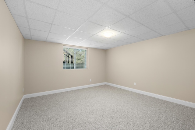 carpeted spare room featuring baseboards and a paneled ceiling