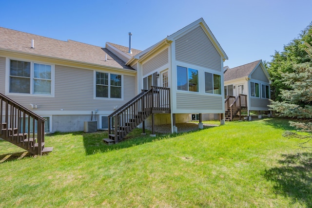 rear view of property with stairs and a yard