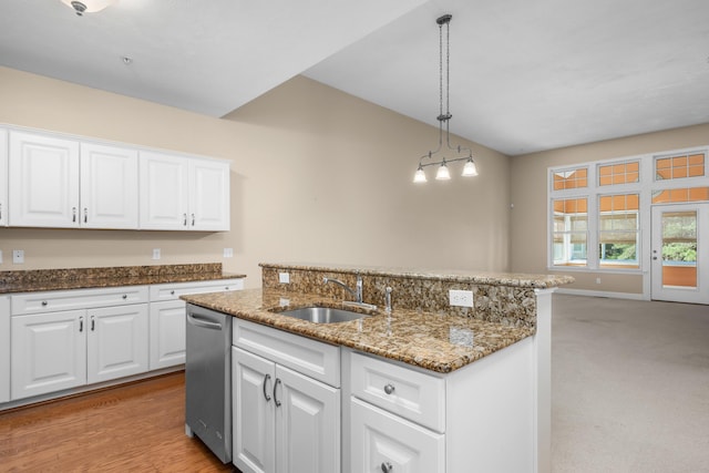 kitchen with stainless steel dishwasher, pendant lighting, dark stone counters, white cabinetry, and a sink