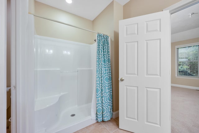 bathroom with baseboards, a shower with shower curtain, and tile patterned floors