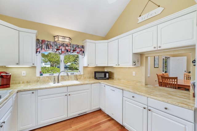 240 Surf Dr, Mashpee, MA 02649 - kitchen featuring a sink, black microwave, white dishwasher, decorative backsplash, and vaulted ceiling