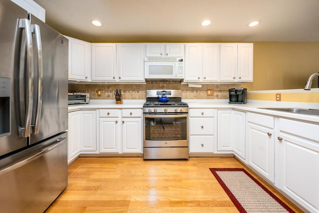 151 Leisure Green Dr N, Mashpee, MA 02649 - kitchen with stainless steel appliances, light countertops, white cabinets, backsplash, and recessed lighting