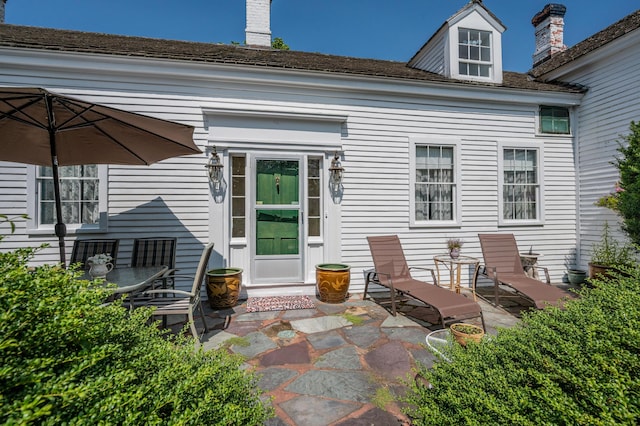 64 Riverside Dr, West Harwich, MA 02671 - back of property featuring a patio and a chimney