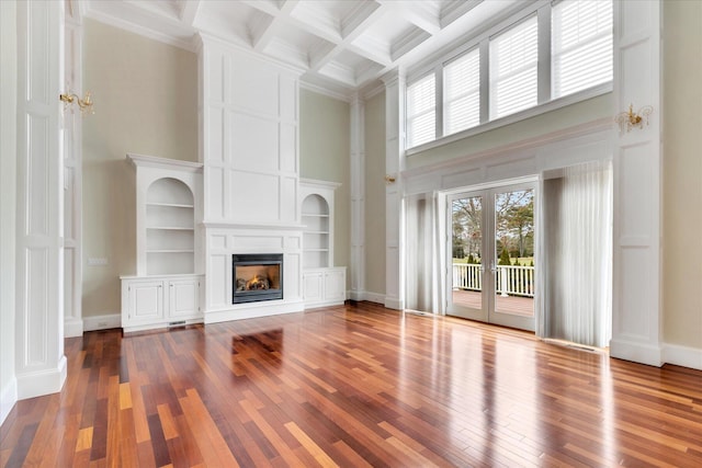 24 Pleasant Park Dr, Mashpee, MA 02649 - unfurnished living room with a towering ceiling, a warm lit fireplace, wood-type flooring, beam ceiling, and coffered ceiling