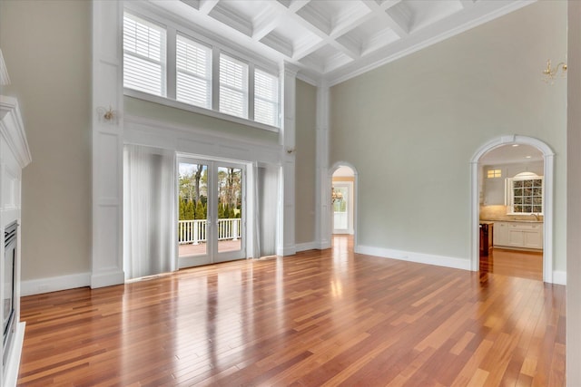 24 Pleasant Park Dr, Mashpee, MA 02649 - unfurnished living room with a towering ceiling, arched walkways, ornamental molding, beamed ceiling, and coffered ceiling