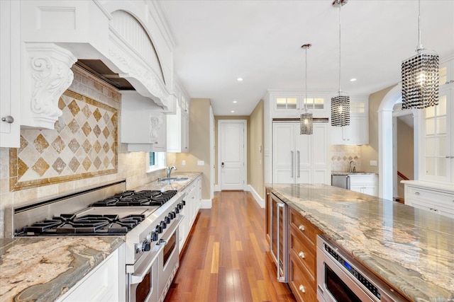 24 Pleasant Park Dr, Mashpee, MA 02649 - kitchen with double oven range, light wood finished floors, recessed lighting, white cabinets, and decorative backsplash