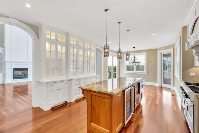 24 Pleasant Park Dr, Mashpee, MA 02649 - kitchen with a glass covered fireplace, appliances with stainless steel finishes, light wood-type flooring, a chandelier, and beverage cooler