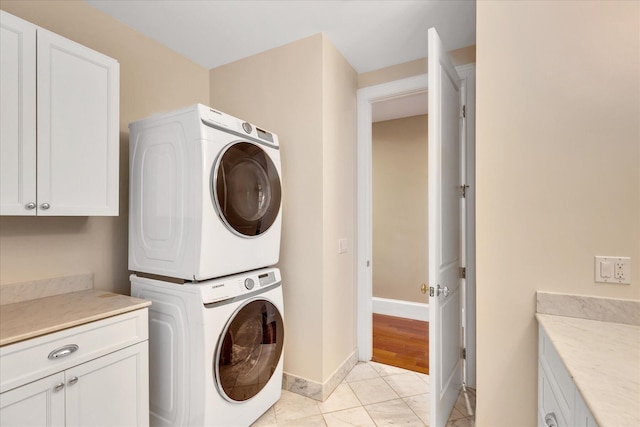24 Pleasant Park Dr, Mashpee, MA 02649 - laundry area with stacked washing machine and dryer, cabinet space, and light tile patterned flooring