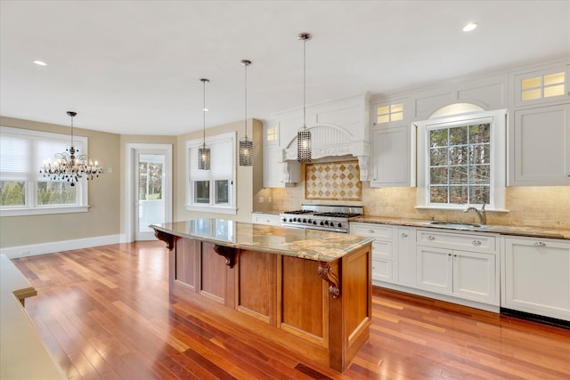 24 Pleasant Park Dr, Mashpee, MA 02649 - kitchen with stainless steel gas stove, backsplash, light stone counters, a chandelier, and recessed lighting