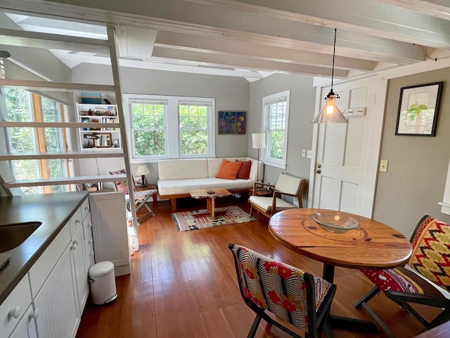 dining area with beam ceiling and dark wood-type flooring