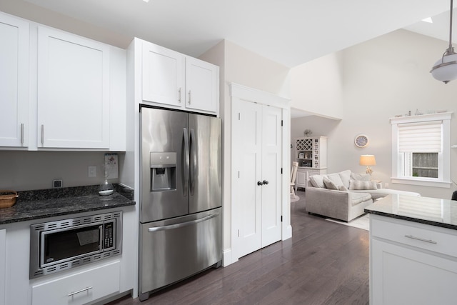 675 Main St Unit C1, Cotuit, MA 02635 - kitchen with appliances with stainless steel finishes, dark wood-type flooring, lofted ceiling, white cabinetry, and dark stone counters