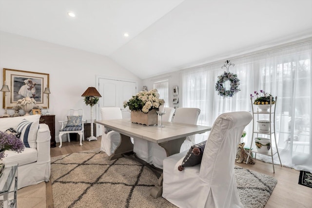 dining area featuring light hardwood / wood-style flooring and vaulted ceiling