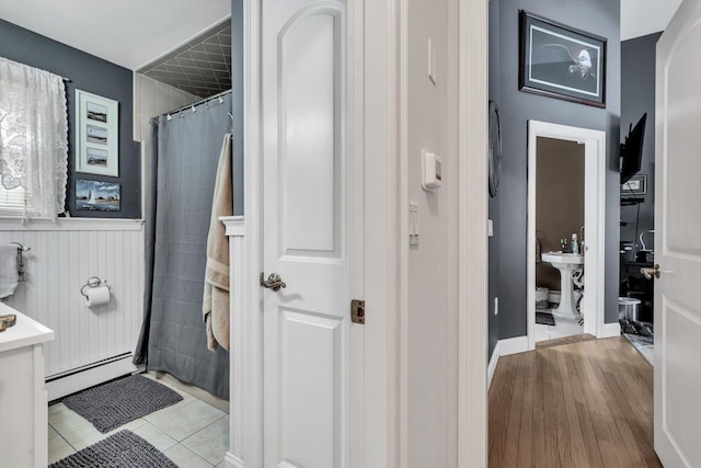 bathroom with tile patterned flooring, a baseboard heating unit, and a shower with shower curtain