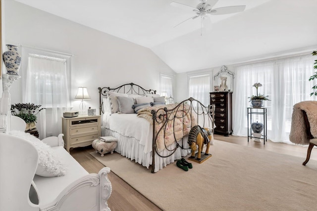 bedroom featuring ceiling fan, light hardwood / wood-style floors, and lofted ceiling