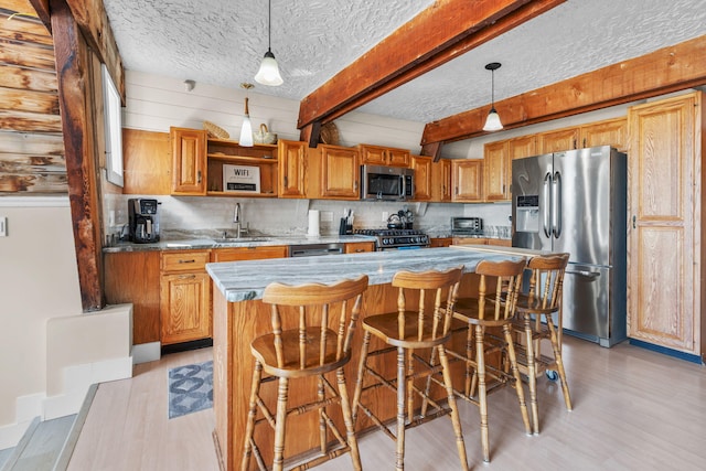133 Breakwater Shores Dr, Hyannis, MA 02601 - kitchen featuring a center island, a sink, light wood-style floors, pendant lighting, and appliances with stainless steel finishes