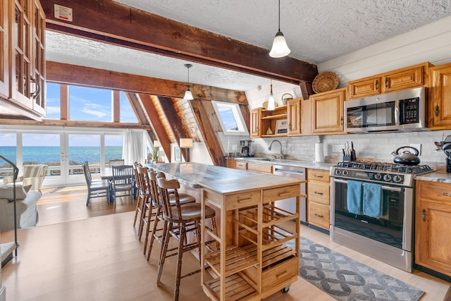 133 Breakwater Shores Dr, Hyannis, MA 02601 - kitchen featuring plenty of natural light, beam ceiling, a textured ceiling, and appliances with stainless steel finishes