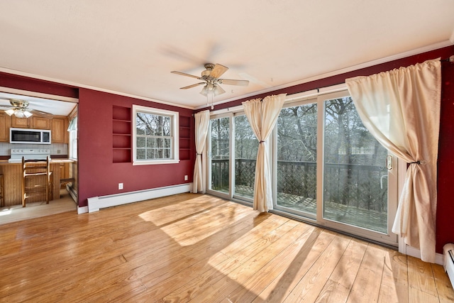 unfurnished sunroom featuring a ceiling fan and a baseboard radiator