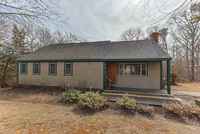 view of front of home with roof with shingles and a chimney