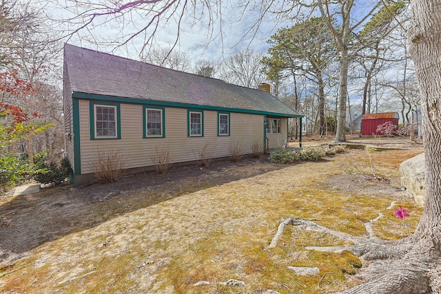 rear view of house with an outdoor structure and a chimney