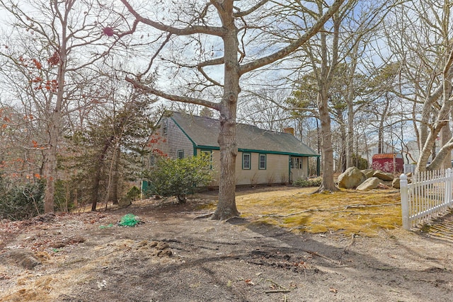 view of side of property featuring fence and a chimney