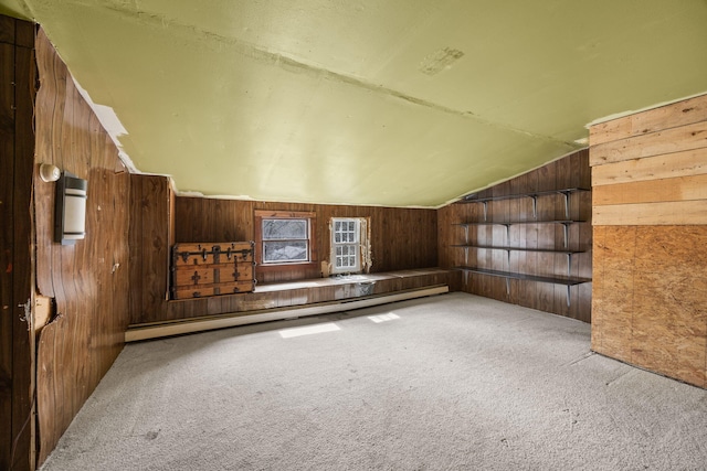 bonus room featuring wooden walls, baseboard heating, lofted ceiling, and carpet