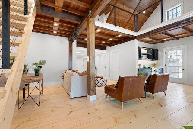 interior space featuring baseboards, wood ceiling, wood-type flooring, high vaulted ceiling, and beam ceiling