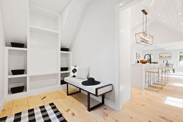 hallway with light wood-style floors, a chandelier, vaulted ceiling, and recessed lighting