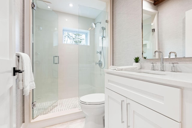 full bathroom featuring a shower stall, toilet, and vanity