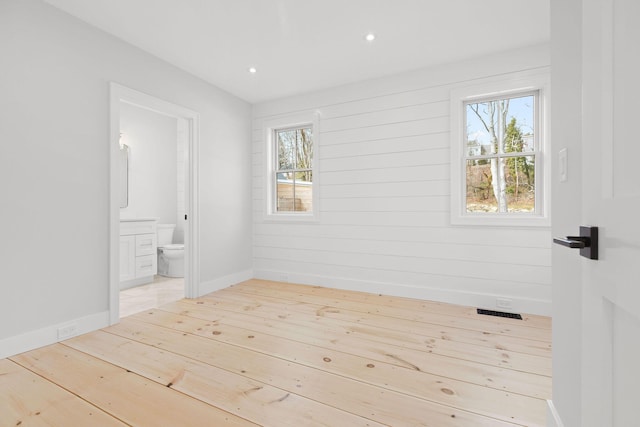 unfurnished room with wood-type flooring, baseboards, a wealth of natural light, and recessed lighting