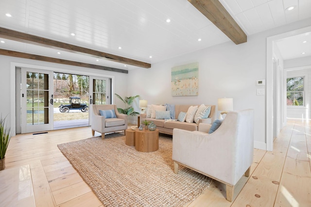 living area featuring visible vents, light wood finished floors, beam ceiling, and recessed lighting