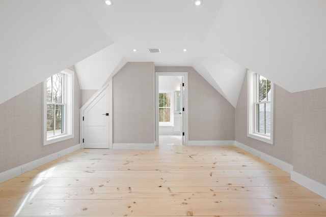 additional living space with lofted ceiling, recessed lighting, hardwood / wood-style flooring, and wallpapered walls