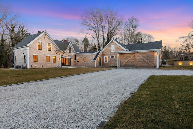 view of front facade with driveway, an attached garage, a lawn, and cooling unit