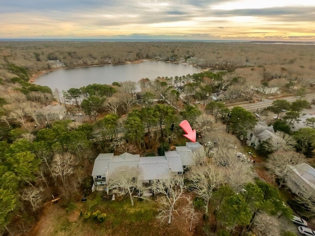 aerial view at dusk featuring a water view