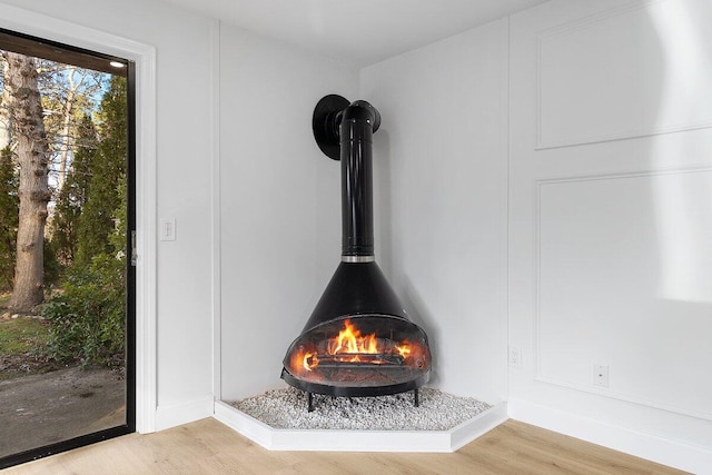 details with a wood stove and wood-type flooring