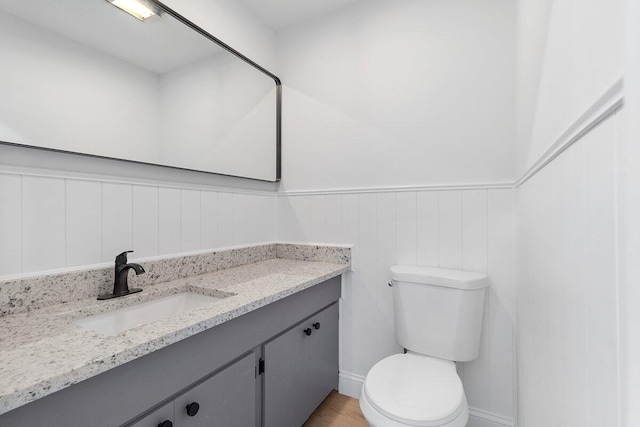 bathroom featuring vanity, toilet, and hardwood / wood-style flooring