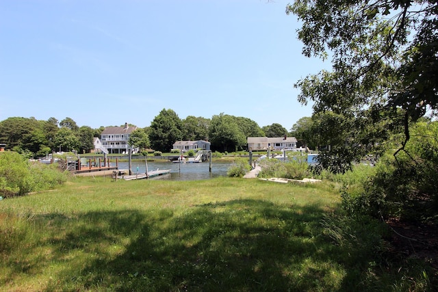 view of yard with a water view and a boat dock