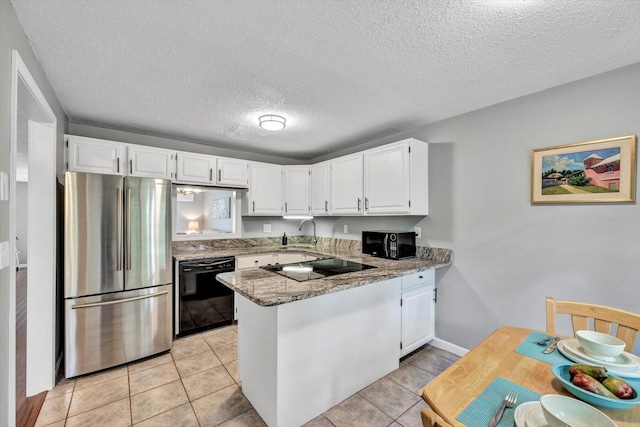 kitchen featuring black appliances, dark stone counters, white cabinets, and kitchen peninsula