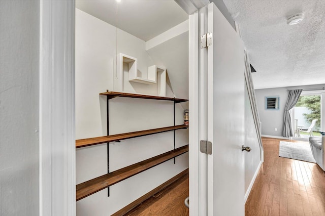 stairway featuring hardwood / wood-style flooring and a textured ceiling