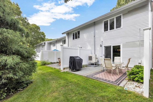 back of property with a yard and a patio