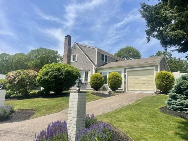 2 Spinning Brook Rd, South Yarmouth, MA 02664 - view of front of home featuring an attached garage, driveway, a chimney, and a front yard