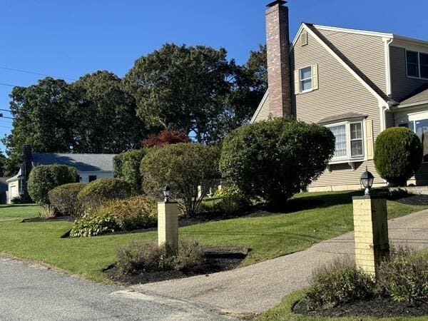 2 Spinning Brook Rd, South Yarmouth, MA 02664 - view of property exterior featuring a chimney and a lawn