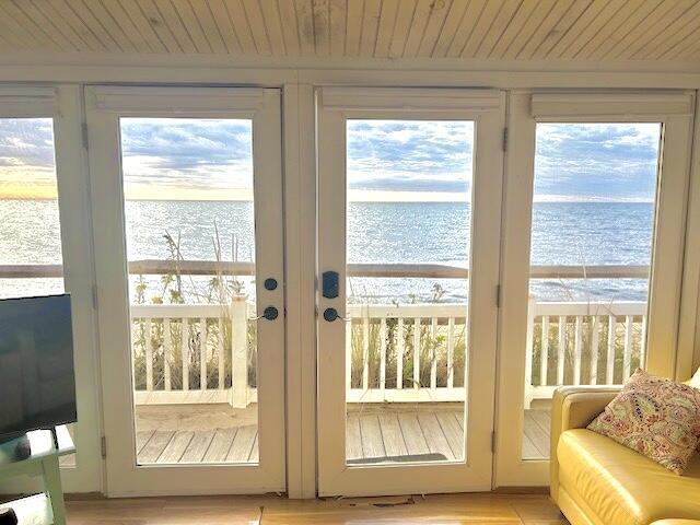 entryway featuring wooden ceiling, a wealth of natural light, and a water view