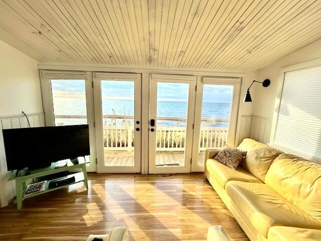 interior space featuring hardwood / wood-style flooring, a water view, and wood ceiling