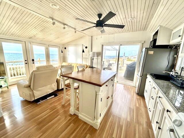 kitchen featuring plenty of natural light, white cabinets, wood ceiling, and light wood-type flooring