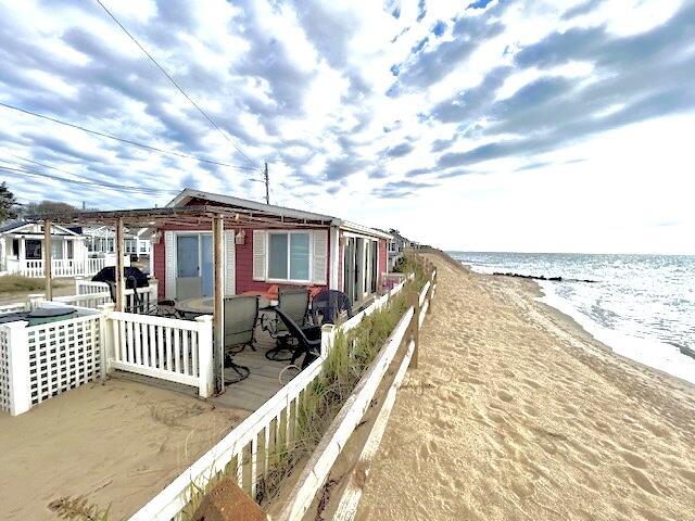 view of side of home featuring a water view and a view of the beach