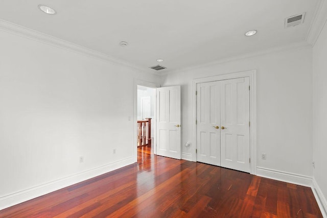 unfurnished bedroom featuring crown molding, hardwood / wood-style flooring, and a closet