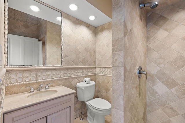 bathroom featuring tile walls, toilet, and vanity