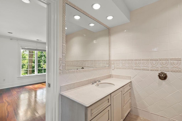 bathroom with hardwood / wood-style flooring, tile walls, and vanity