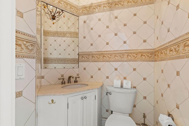 bathroom with tile walls, toilet, and vanity